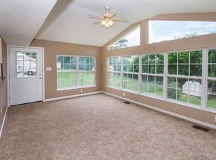 Finished sunroom with a wall of windows and new carpet
