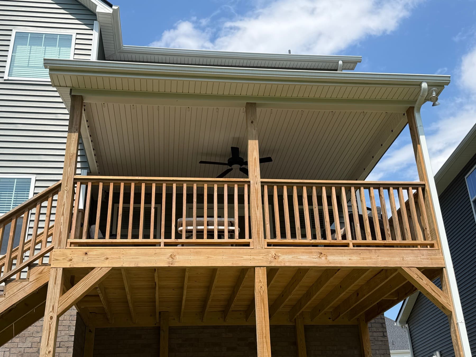 Exterior view of the covered deck framing, railing, and finished ceiling