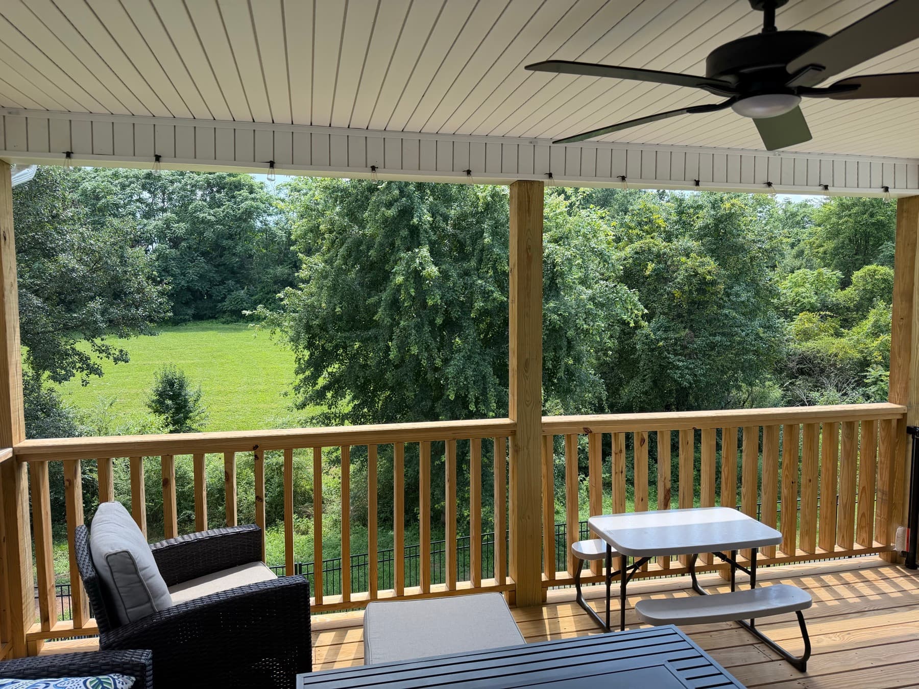 Covered deck overlooking a green East Tennessee backyard