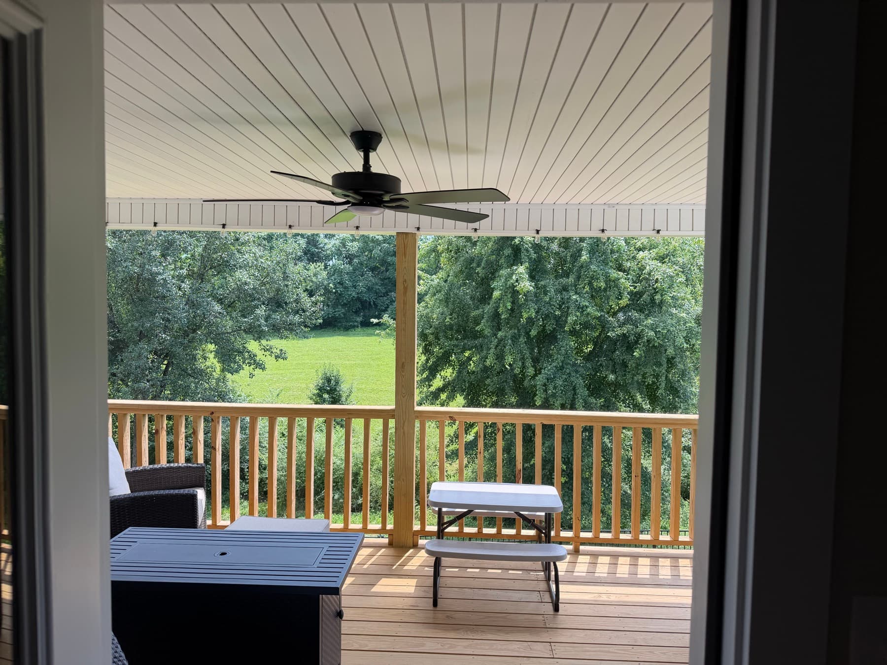 Covered deck and railing viewed from the house doorway