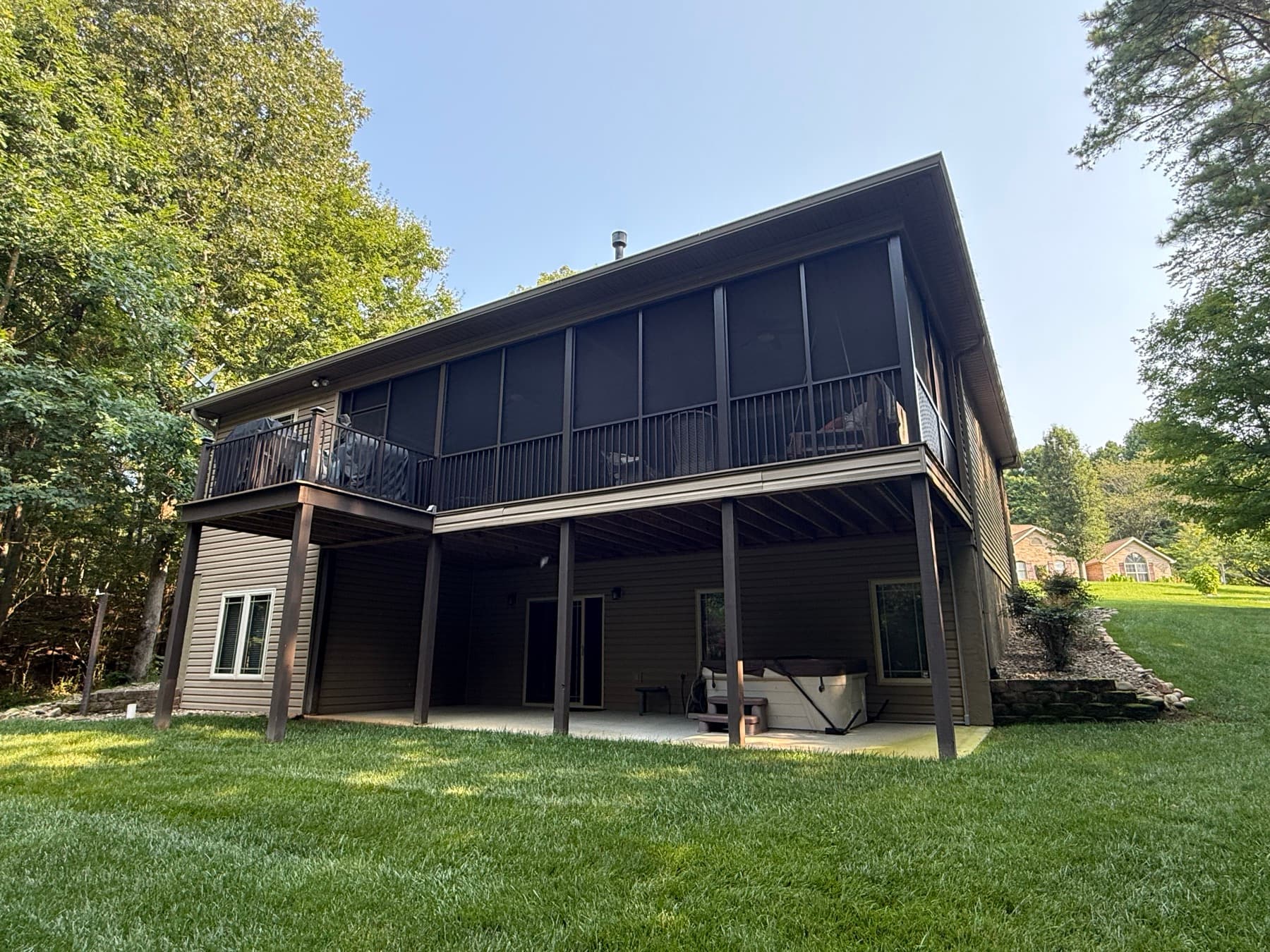 Full rear elevation of an elevated screened porch and adjoining deck
