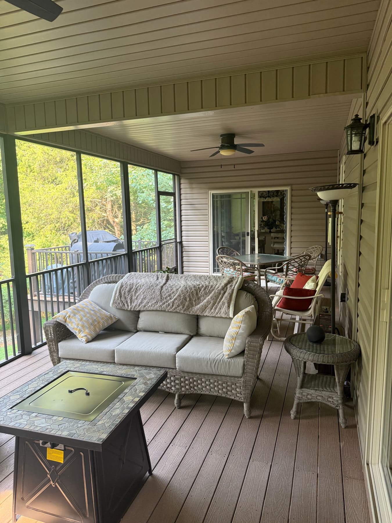 Furnished screened porch with seating and a wooded view