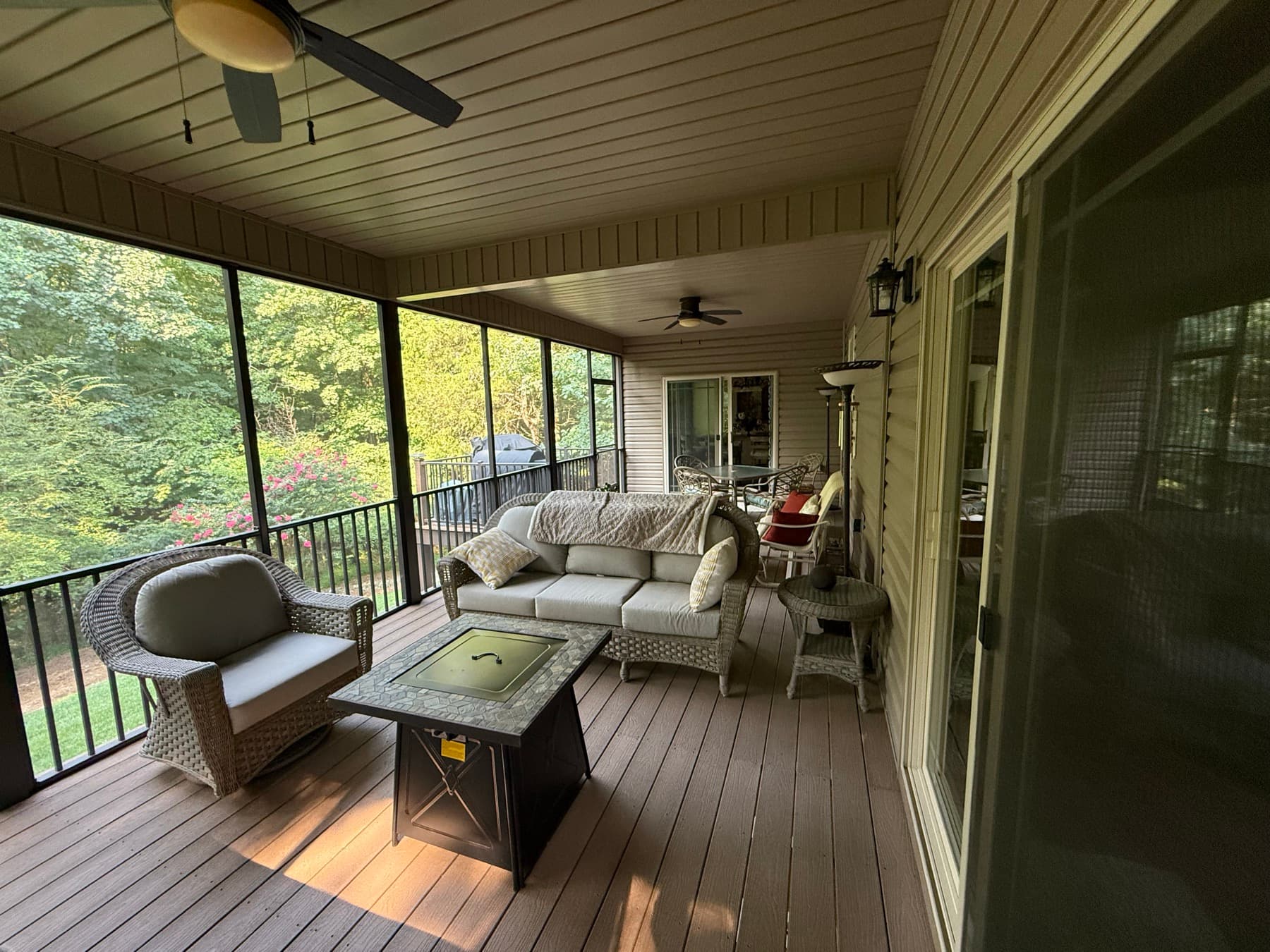 Furnished screened outdoor living room with wooded view